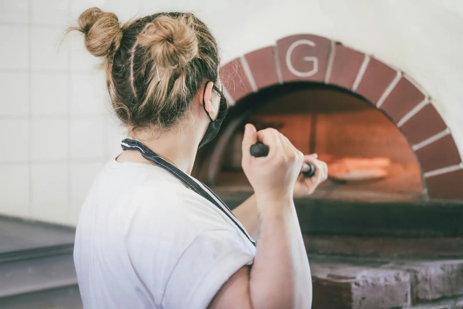 Pizzaïolo devant un four à bois