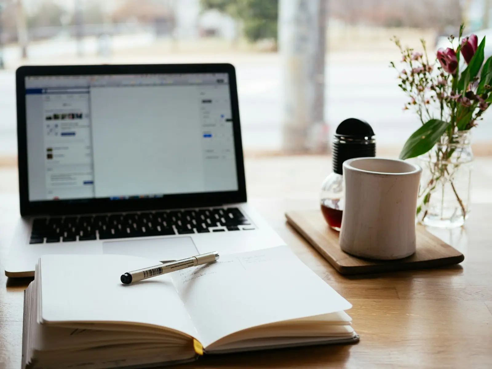 Ordinateur portable et carnet ouvert sur un bureau