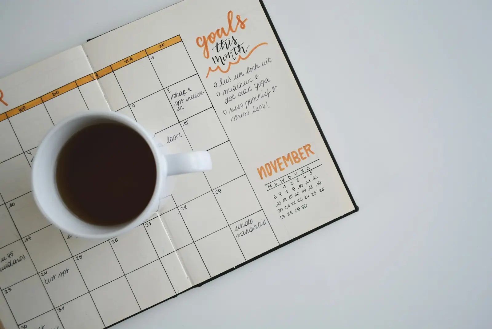 Bureau avec un carnet, un stylo et une tasse de café
