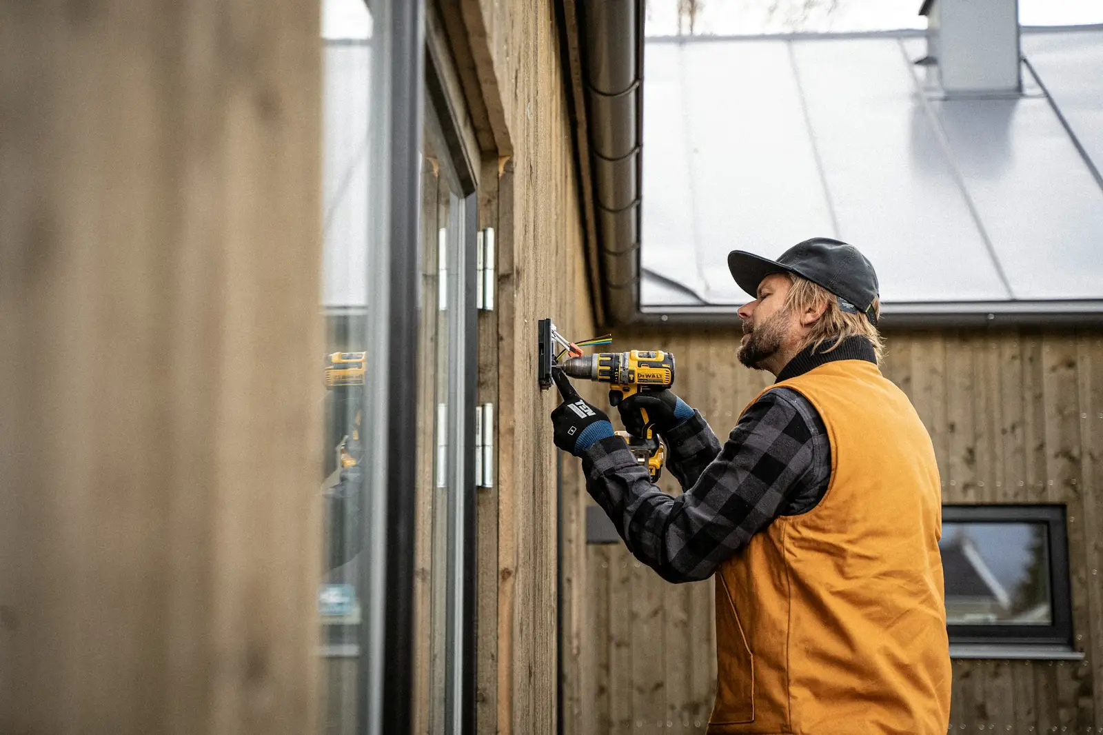 Artisan qui fixe un châssis à la visseuse