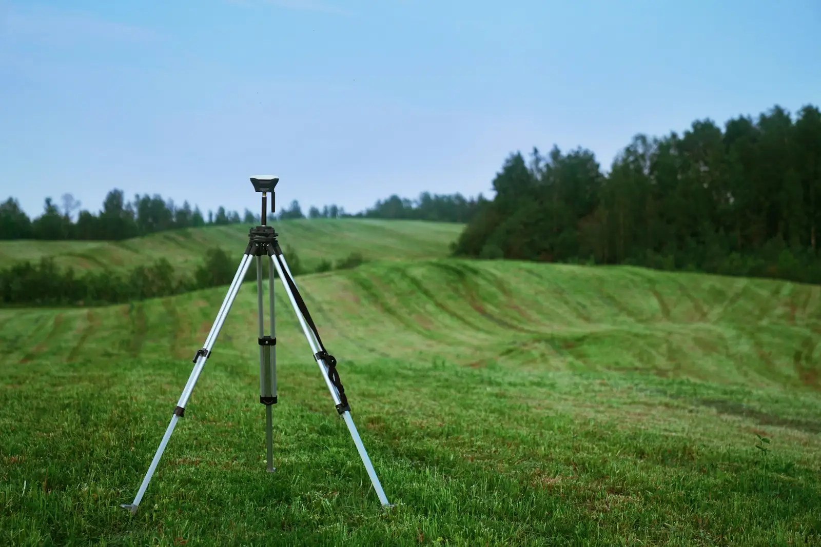 Trépied de géomètre dans une prairie