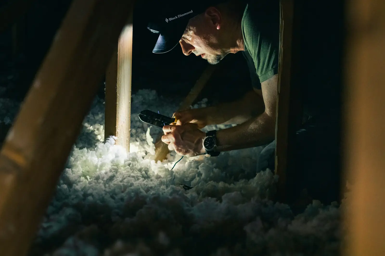 Artisan qui pose de l’isolant dans des combles
