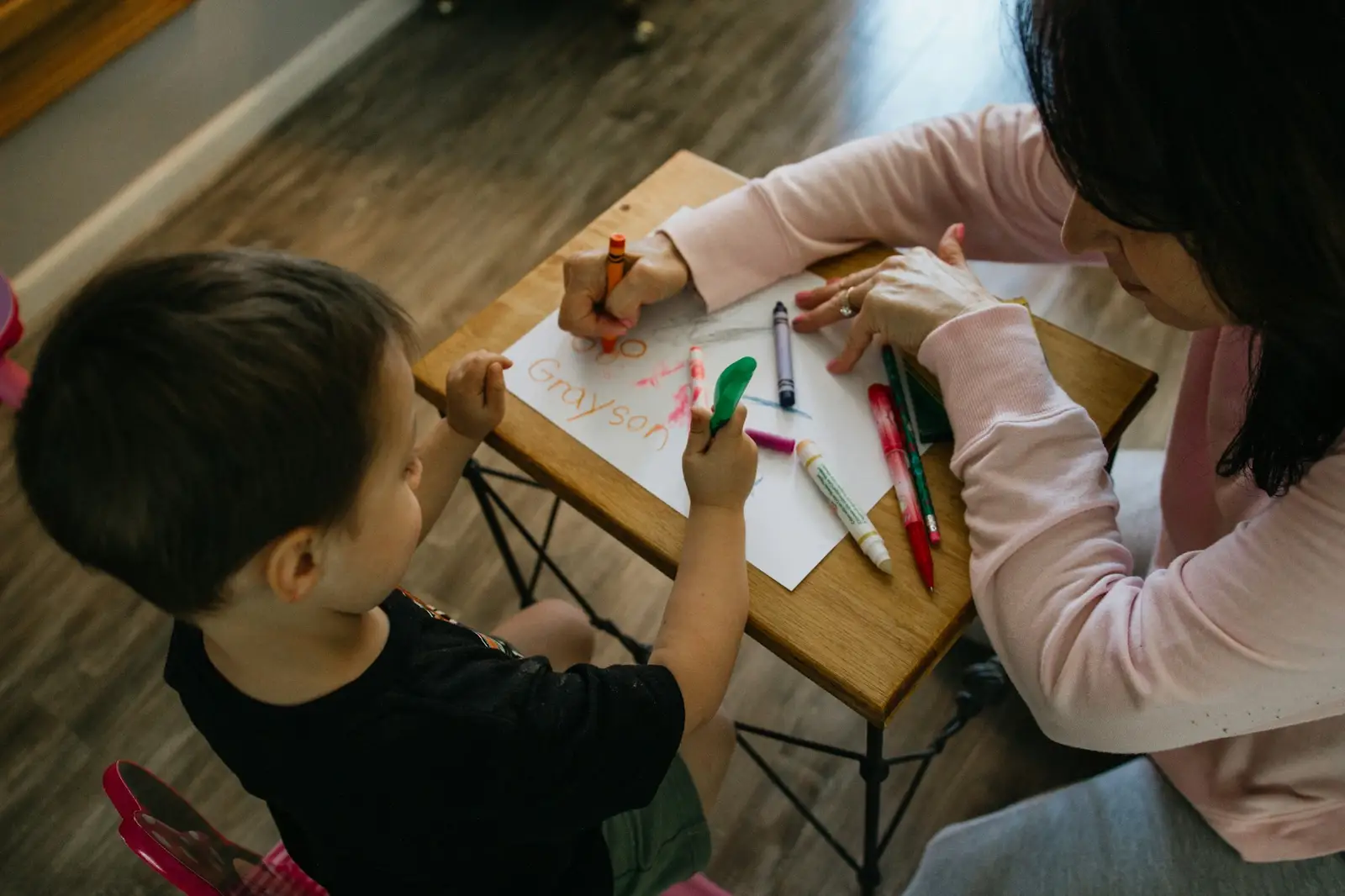 Adulte et enfant qui dessinent à une table