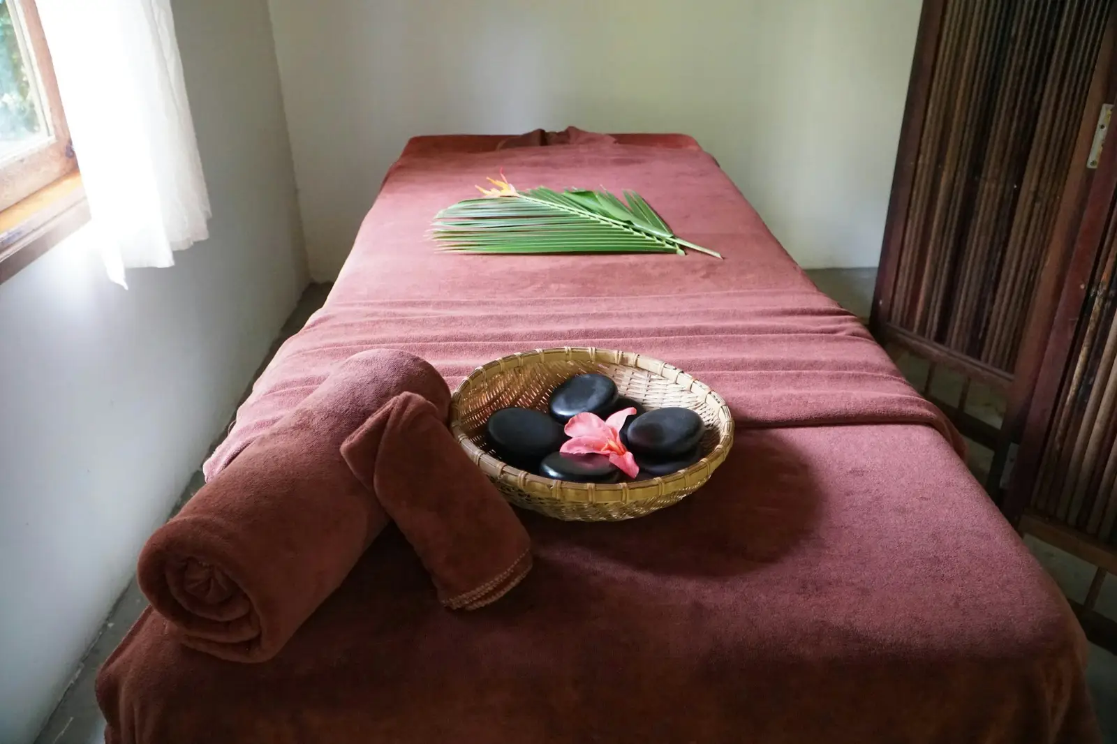 Table de massage, serviette et pierres chaudes