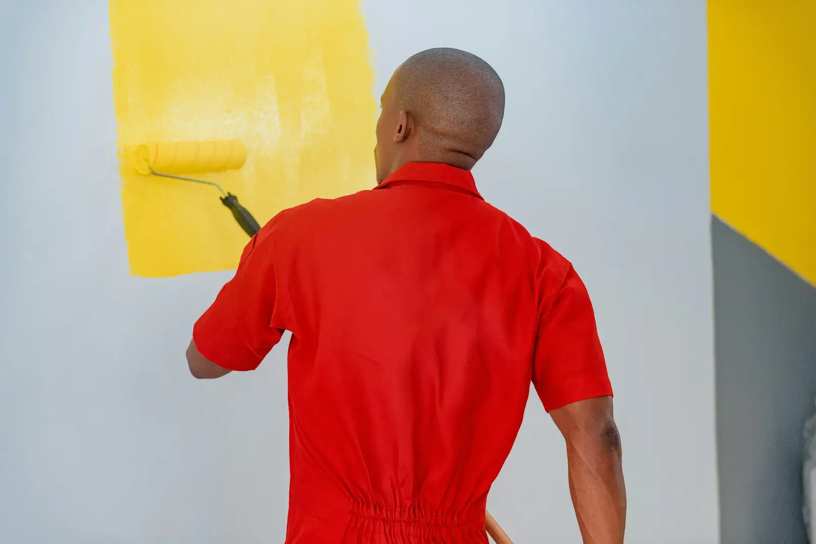 Peintre en bâtiment peignant un mur