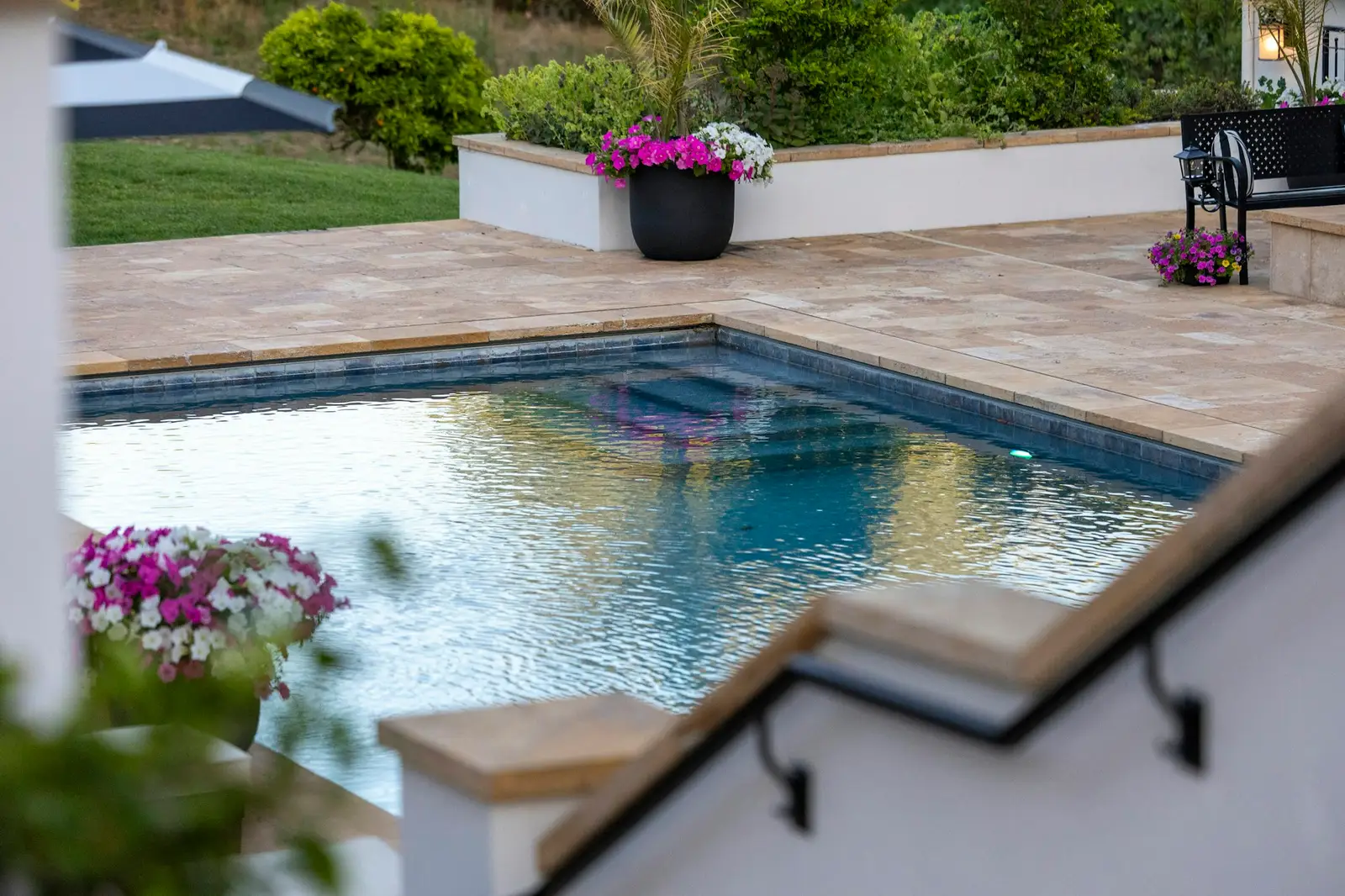 Piscine extérieure entourée d’une terrasse fleurie