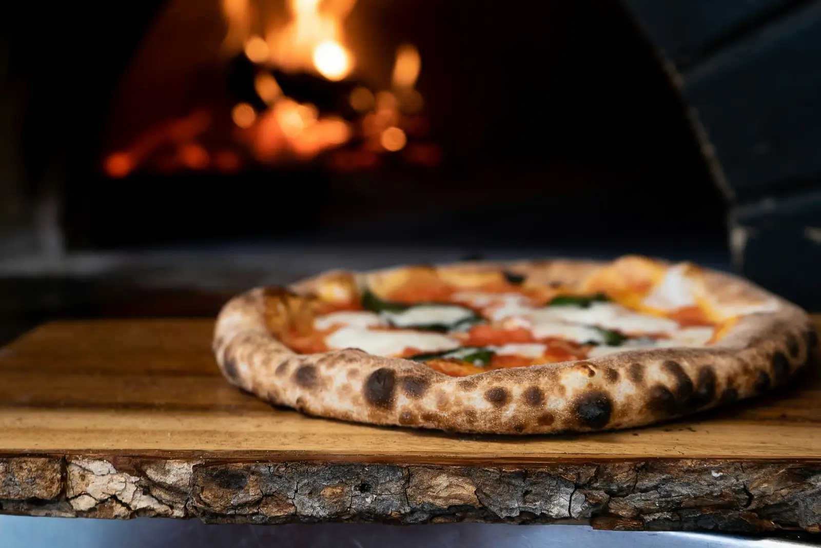 Pizza devant le four à bois