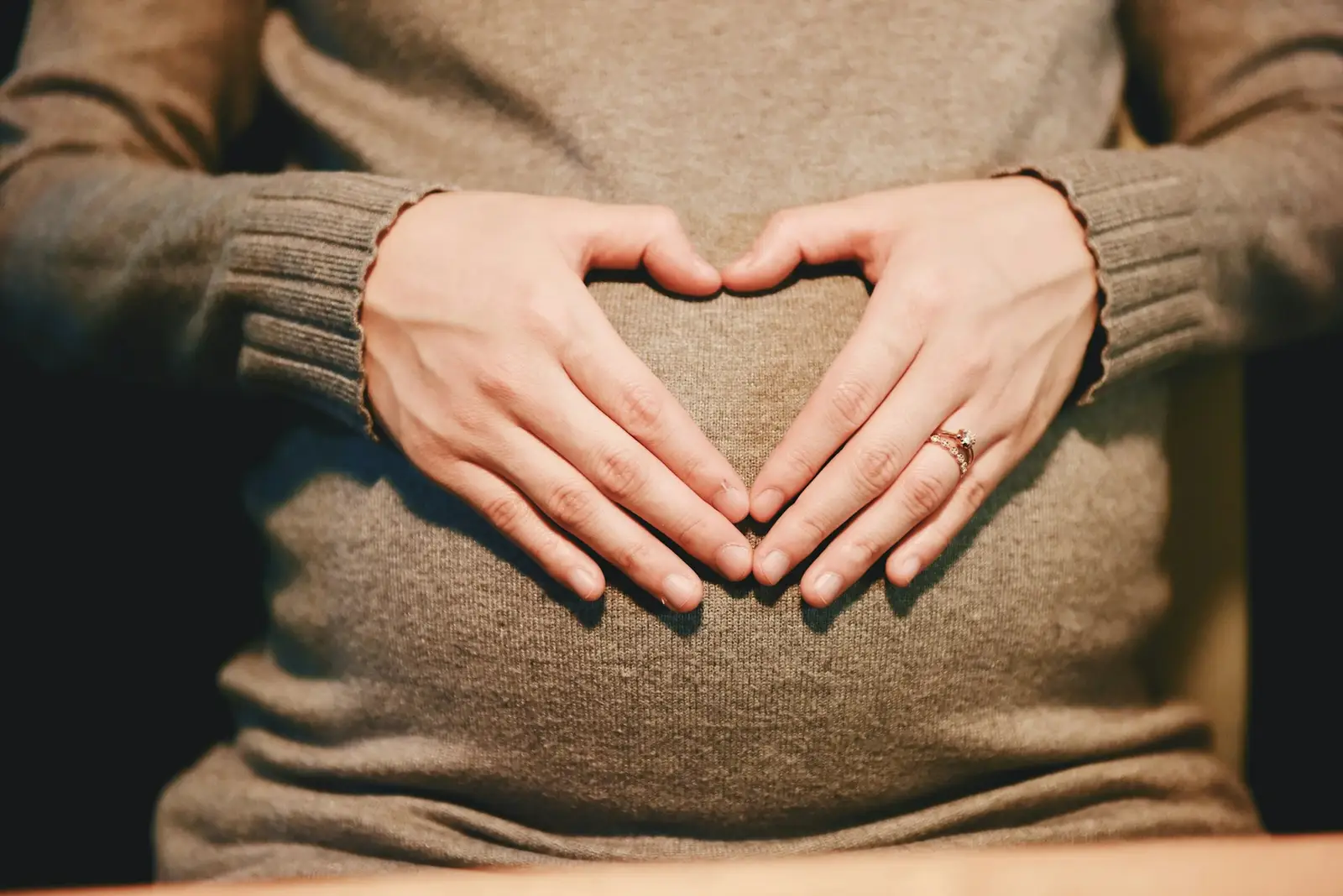 Mains en forme de cœur sur le ventre d’une future maman
