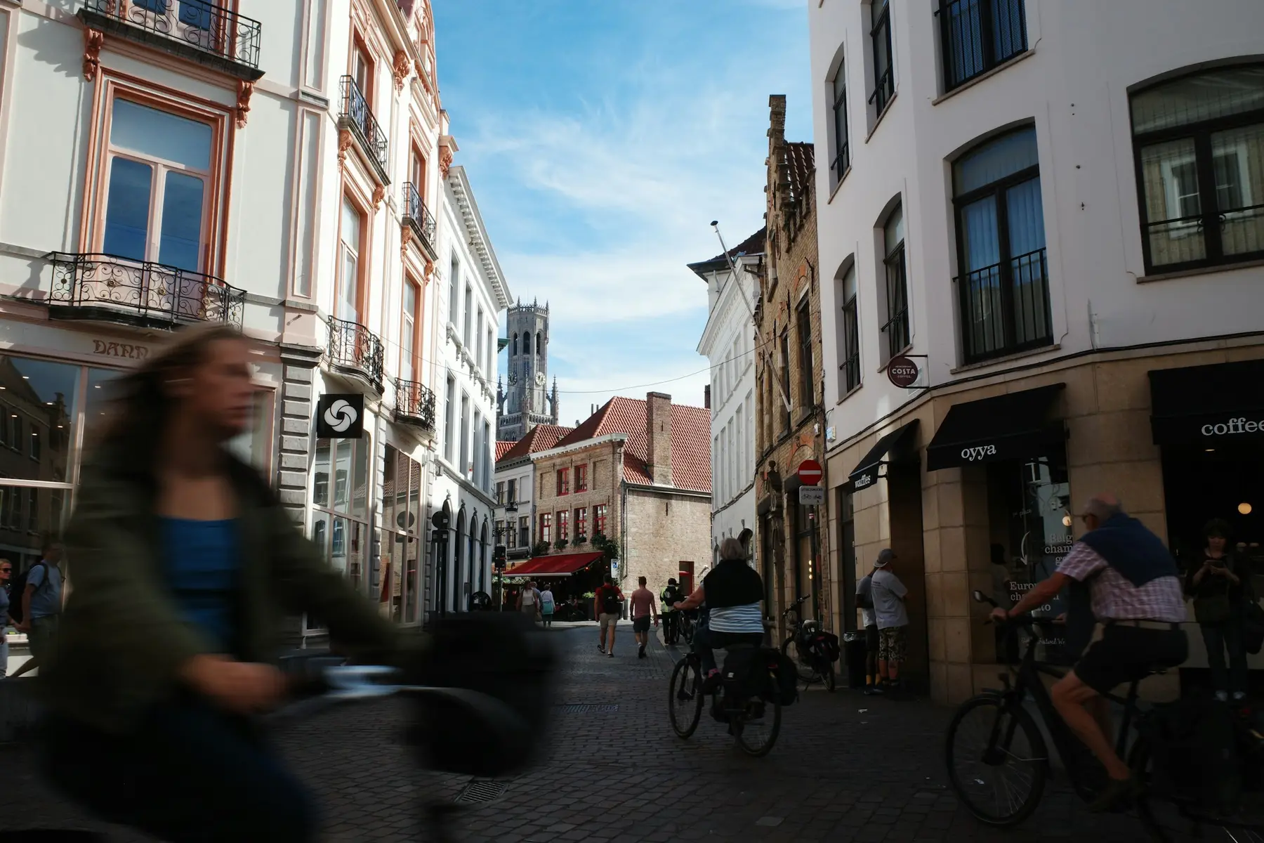 Cyclistes dans une rue pavée d’une ville belge