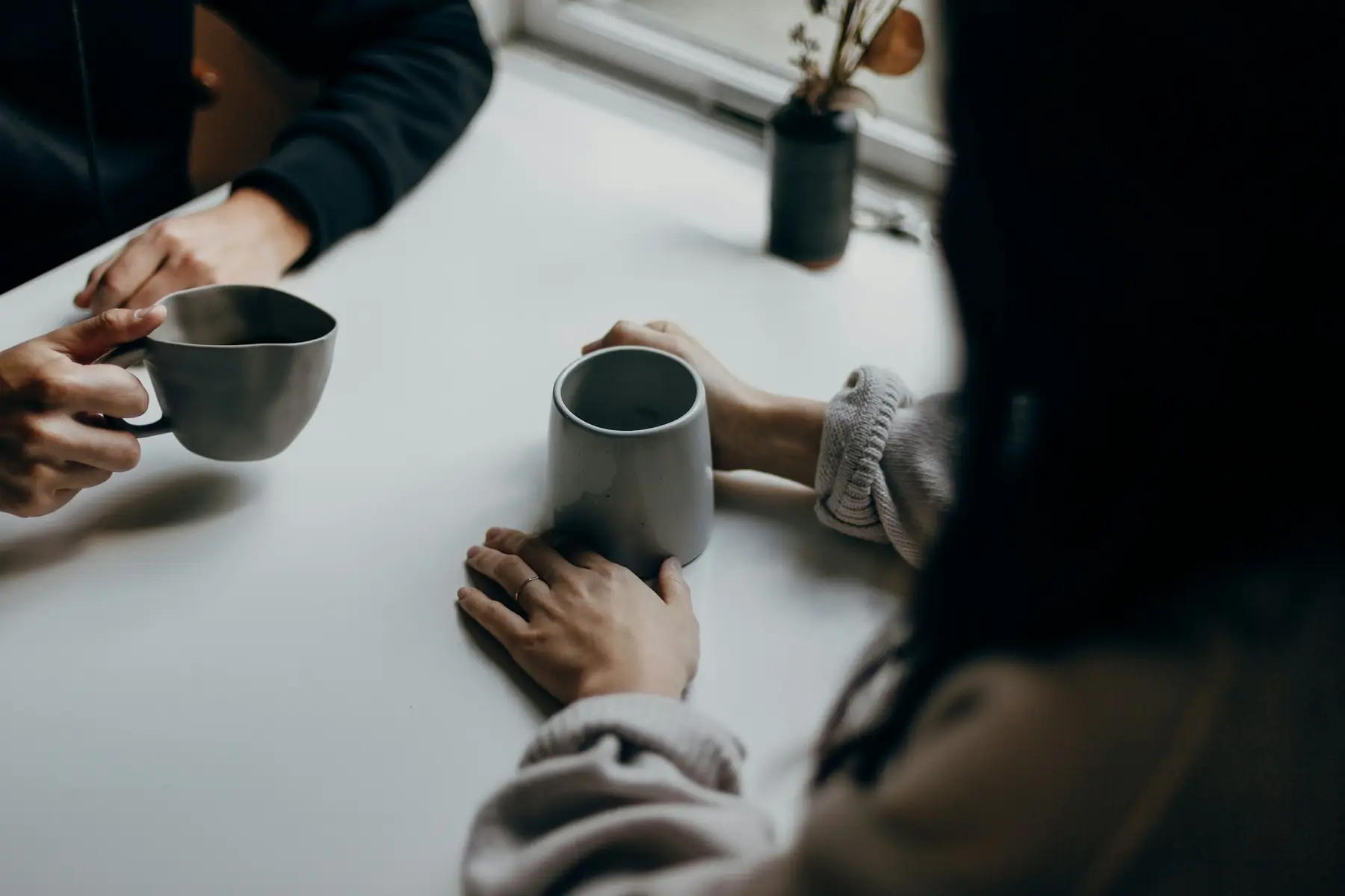 Deux personnes en conversation autour d’un café