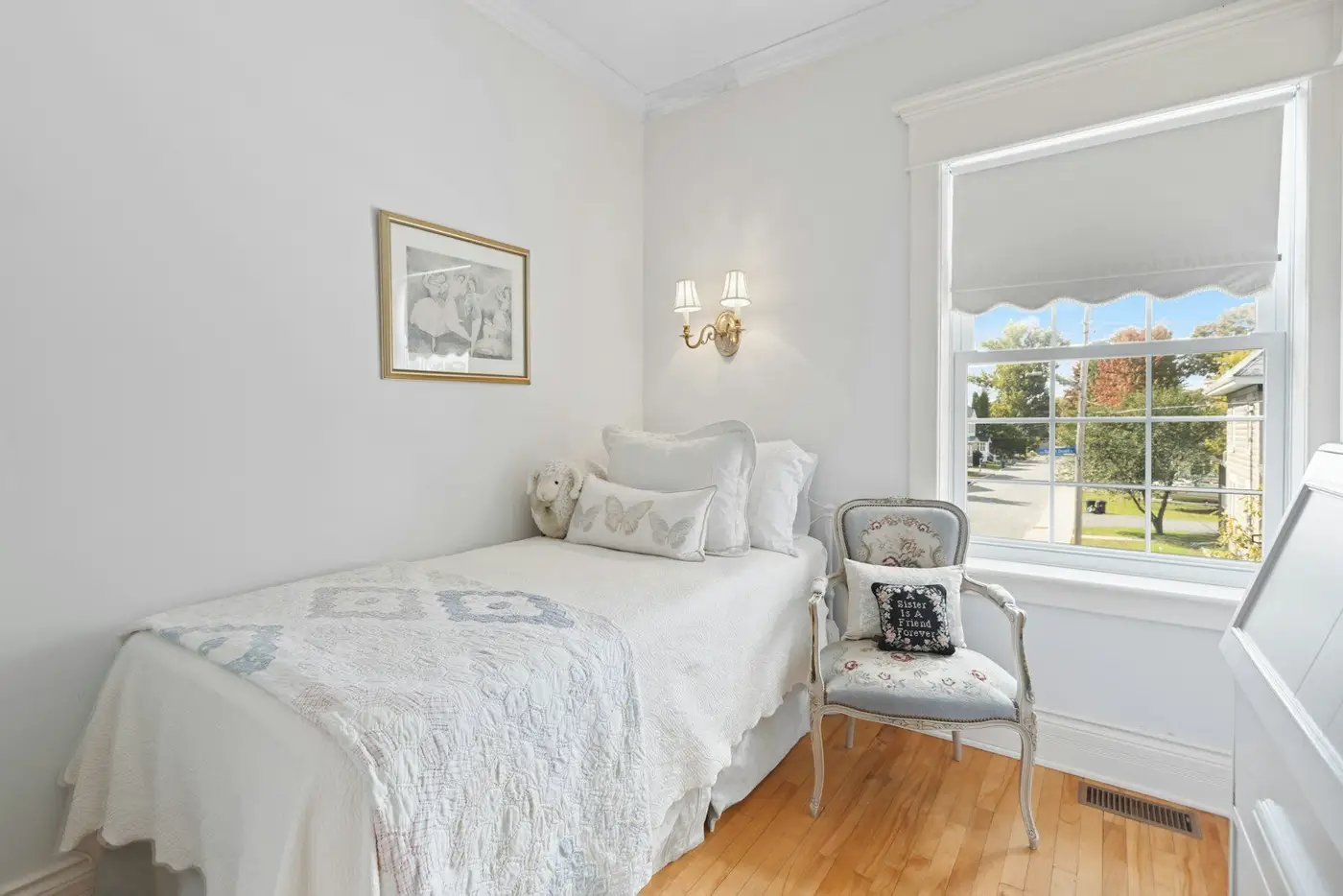 Chambre d’hôtes avec un lit blanc et un fauteuil